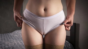 Middle-aged woman in hosiery provocatively exposes her underwear and thigh spread